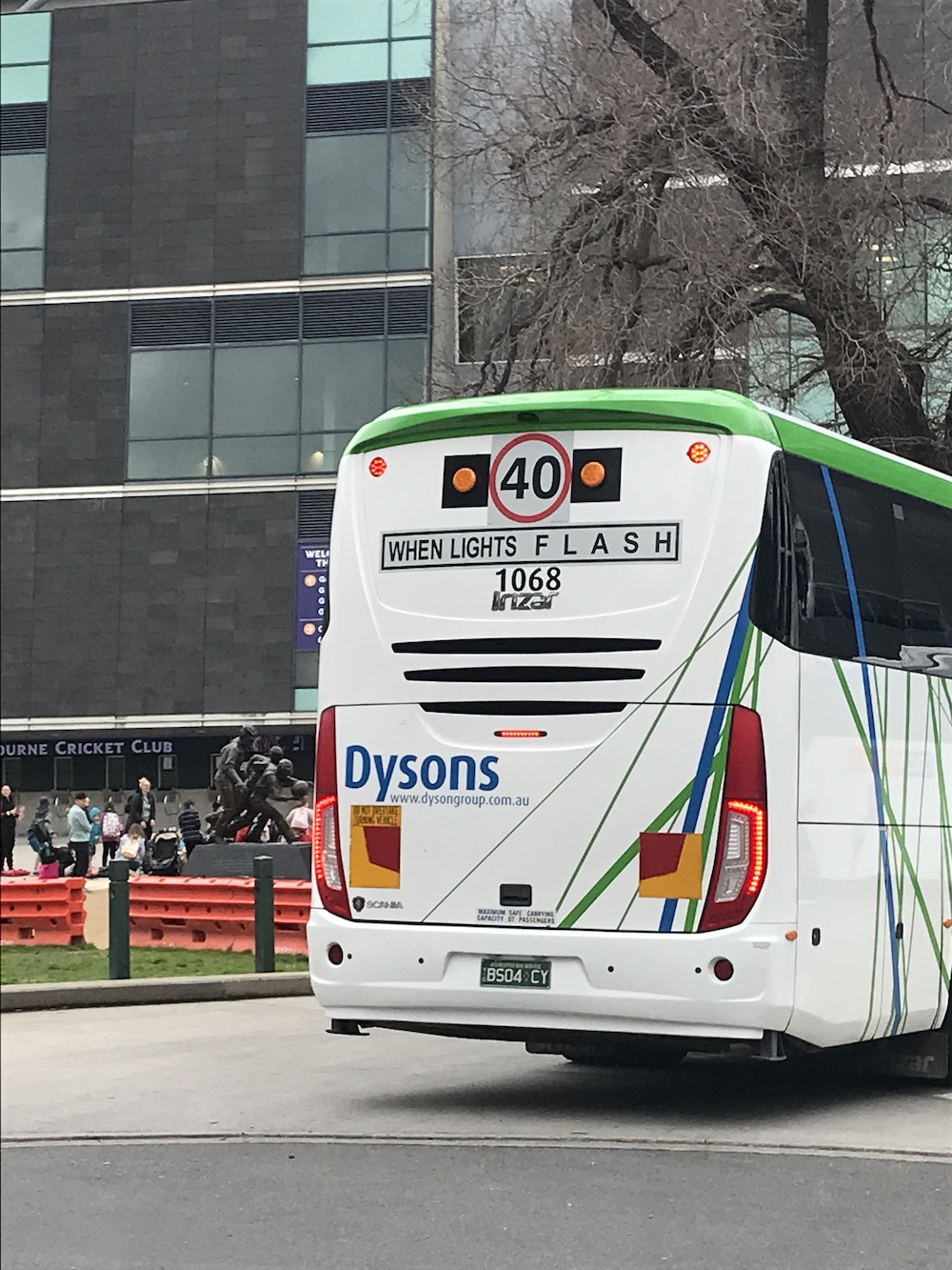 A bus with the text 'WHEN LIGHTS F L A S H' on a sign on the back