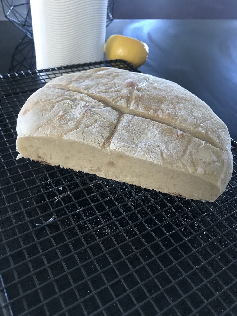 a flat pale loaf of bread, with a cut side facing away