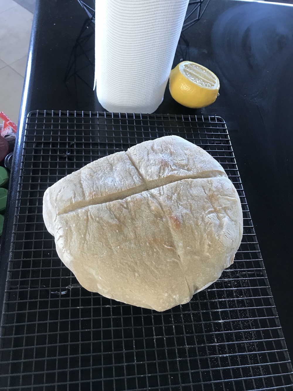a flat pale loaf of bread, with a cut side facing the camera, you can see the tiny bubbles in it