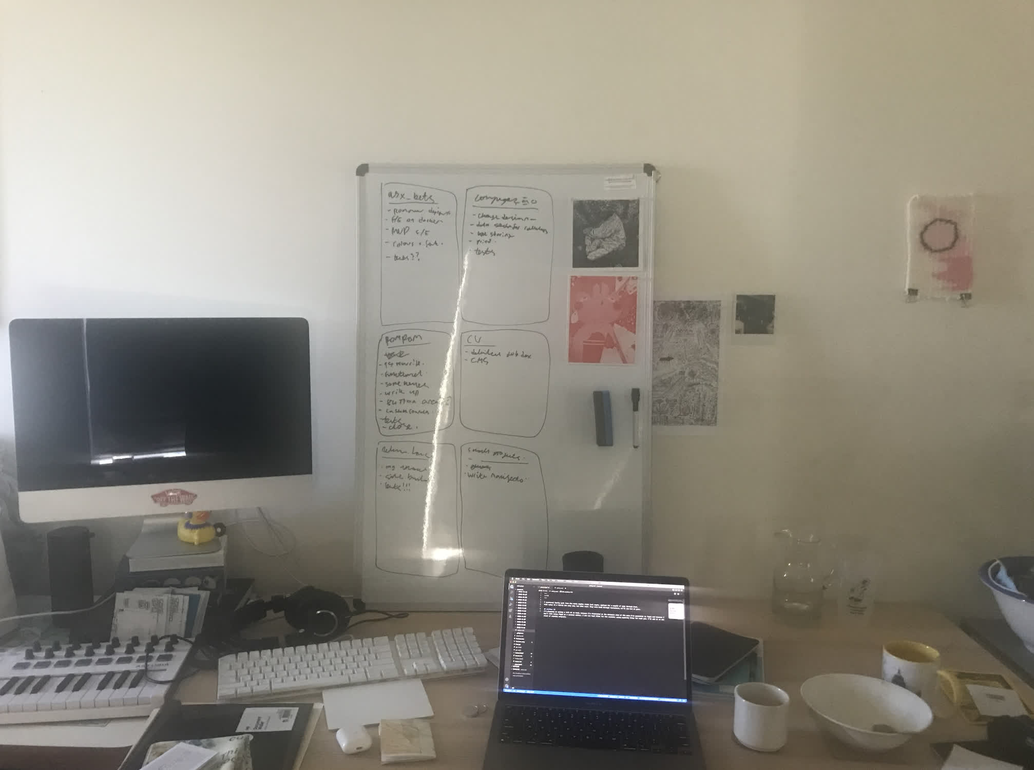 a messy desk, a white board with rectangles scrawled on it, outlining my current projects