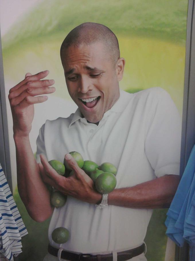 a man struggling to hold a bunch of limes
