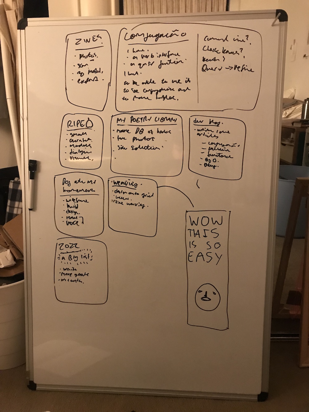 a whiteboard with a bunch of projects listed on it in messy handwriting, and the text "WOW THIS IS SO EASY" next to a scribbled round face